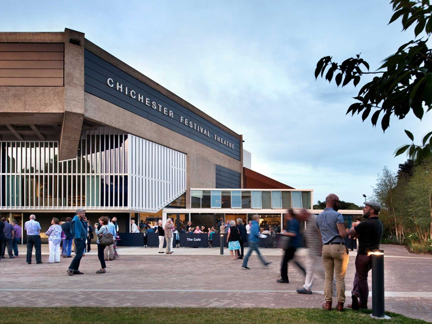 A group of people are walking in front of a building that says chichester