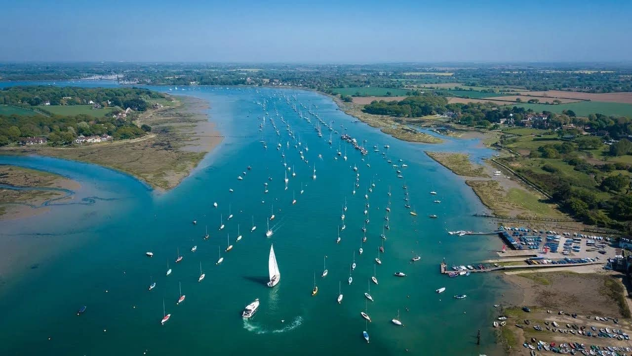 An aerial view of a large body of water filled with boats.