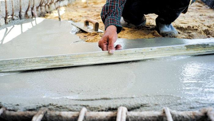 a man working on a slab of concrete