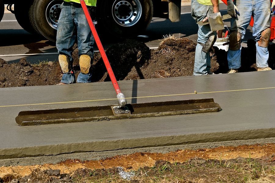 a group of men standing around a cement slab