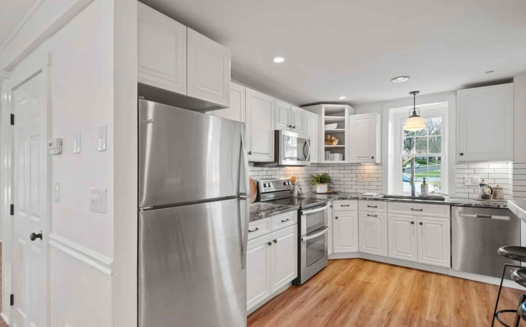 A kitchen with white cabinets and stainless steel appliances.