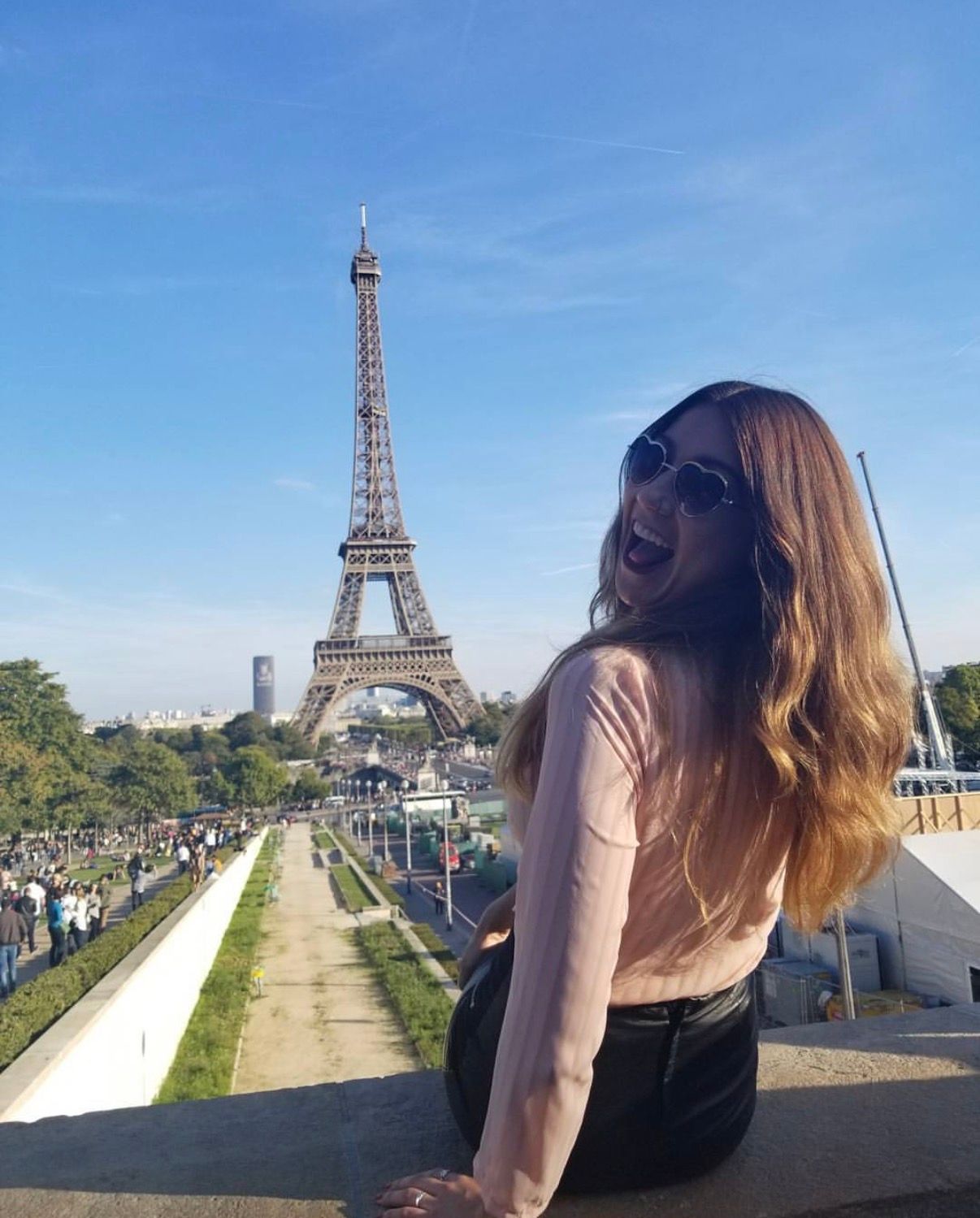 Smiling at the Eiffel Tower in Paris on a sunny day