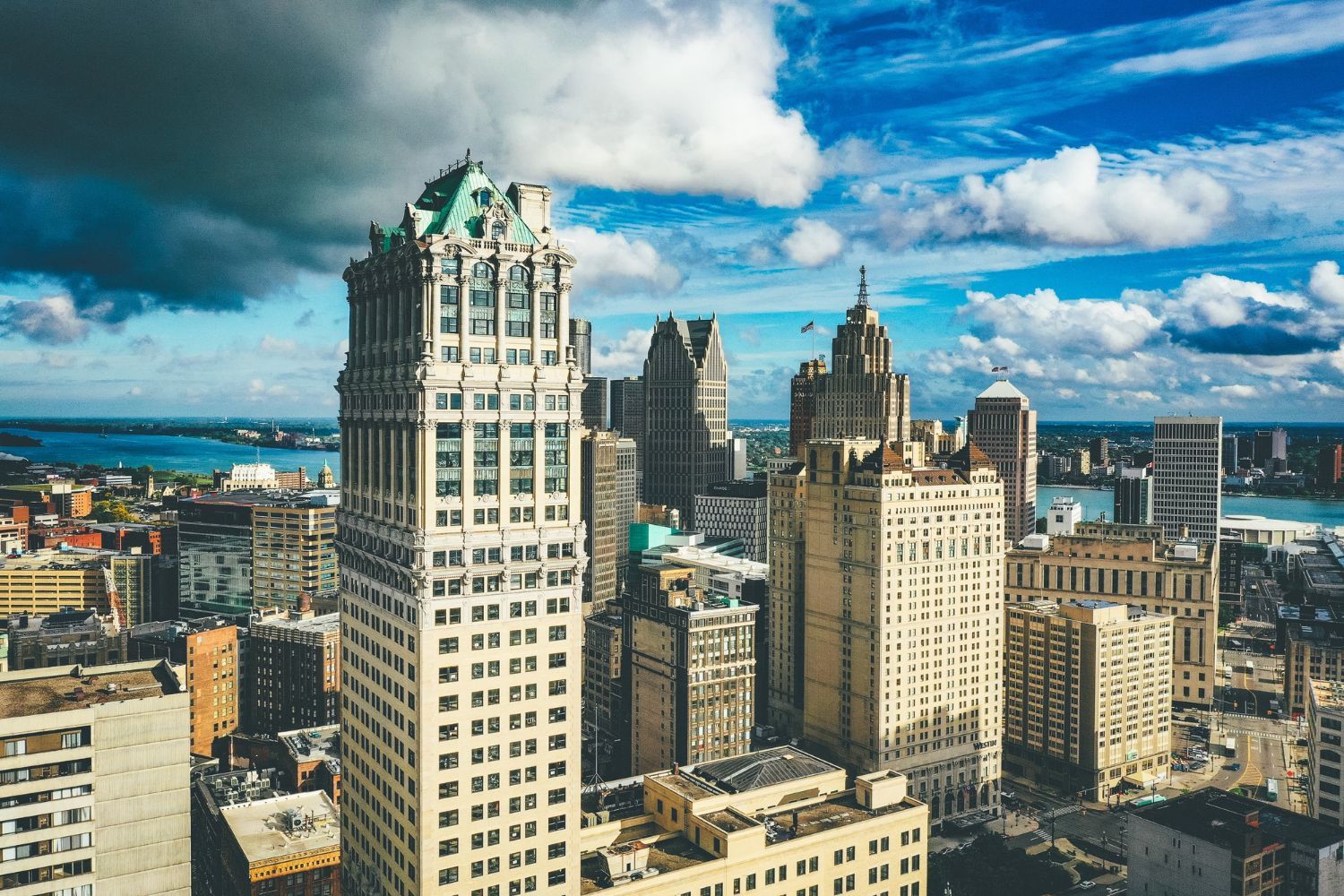 Aerial view of the Detroit skyline, featuring the historic Art Deco Guardian Building under a partly cloudy sky.