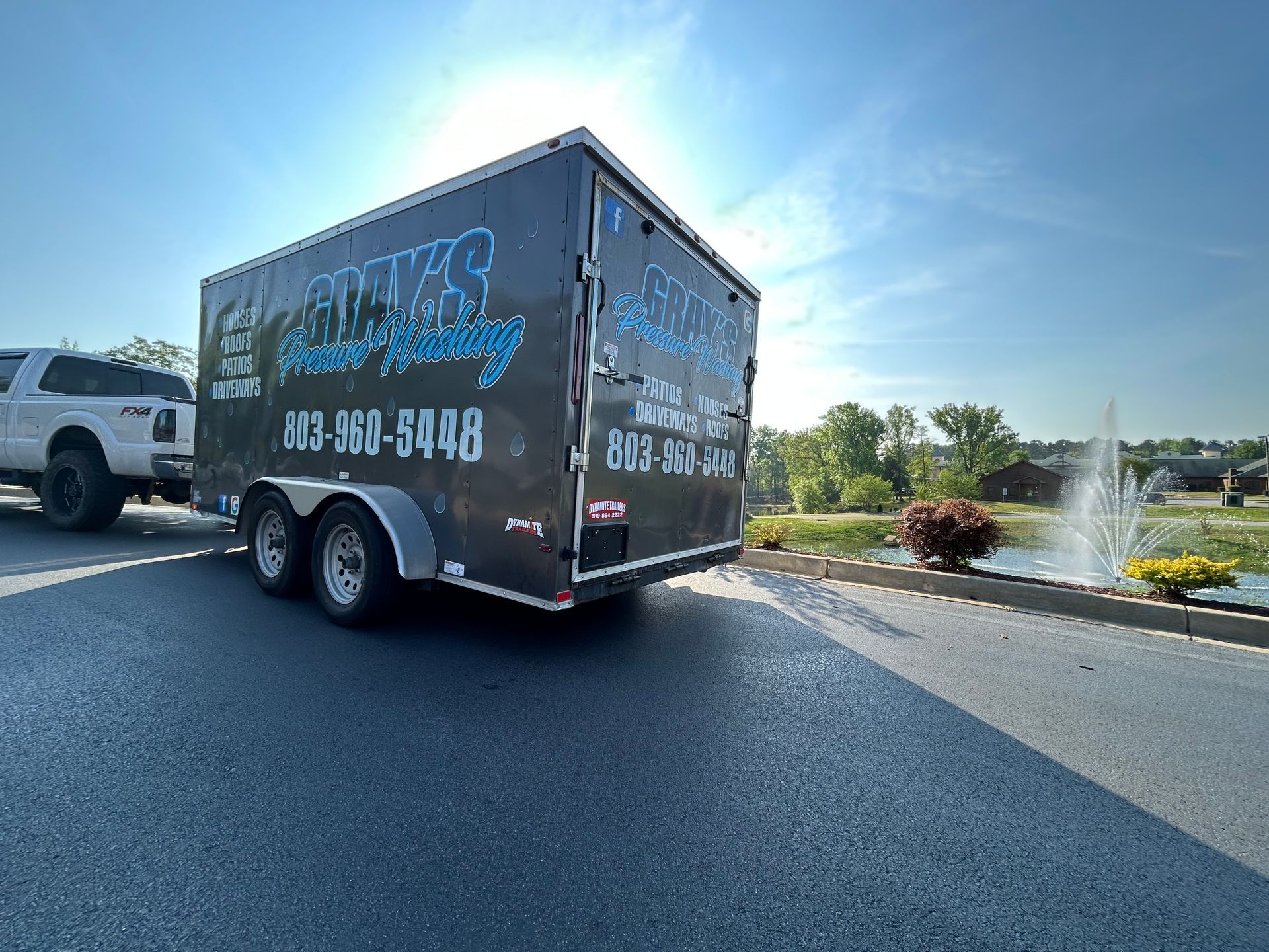 gray 's pressure washing trailer is parked on the side of the road