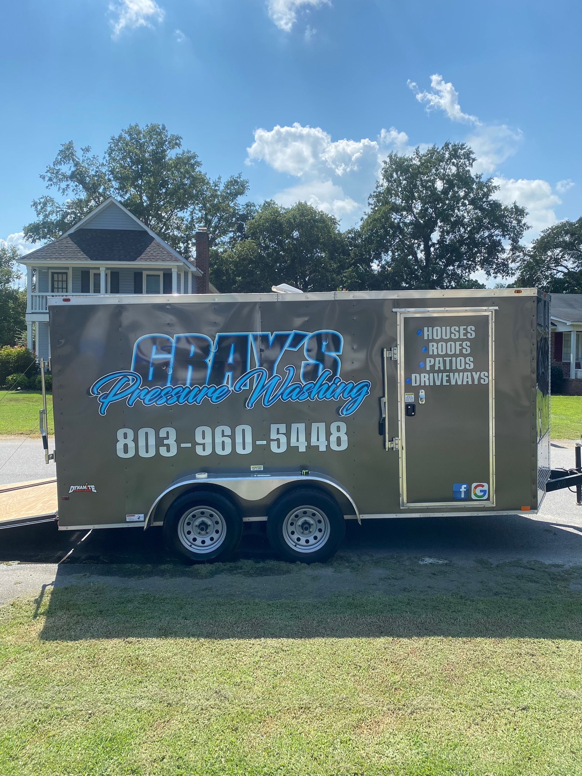 gray 's pressure washing trailer is parked on the side of the road