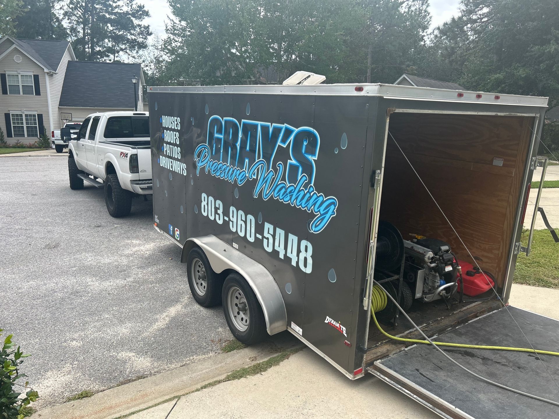 a trailer for gray 's pressure washing is parked in front of a house