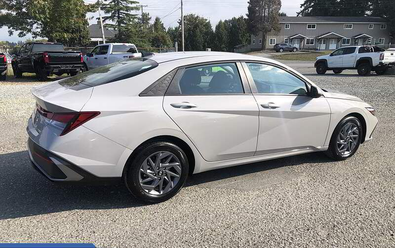 White Hyundai sedan parked on gravel lot.