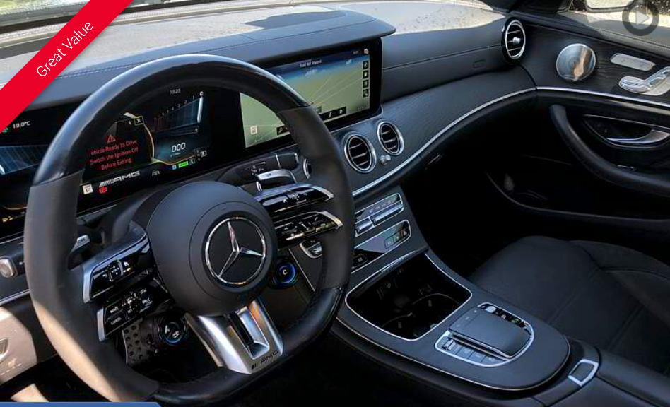 Black Mercedes-Benz interior with dashboard, steering wheel, and display screens visible.