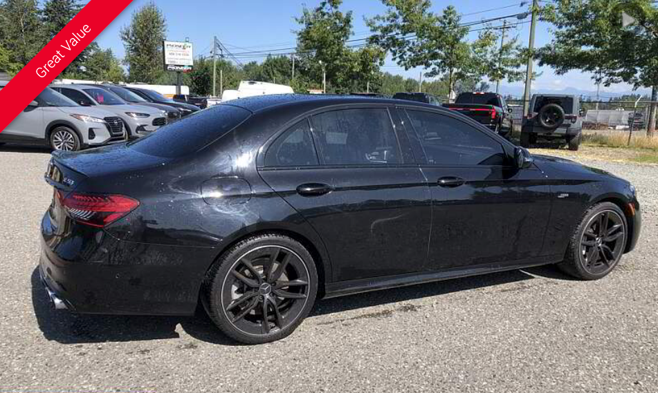 Black sedan parked outside on a sunny day.