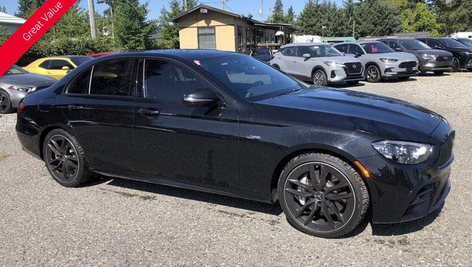 Black Mercedes sedan parked in a lot with other cars.