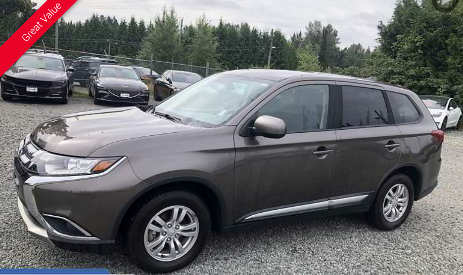 Gray Mitsubishi Outlander SUV parked in a car lot with other vehicles.