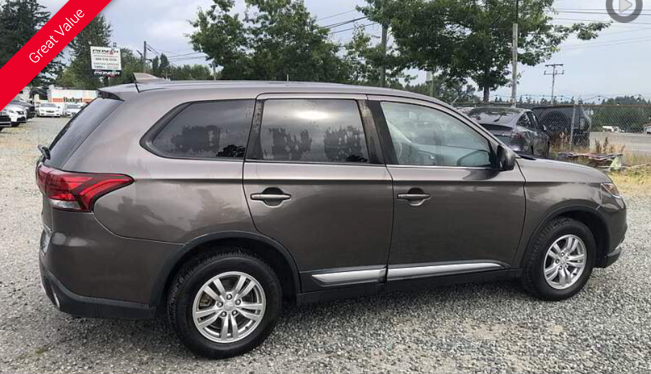 Brown Mitsubishi SUV parked outdoors.