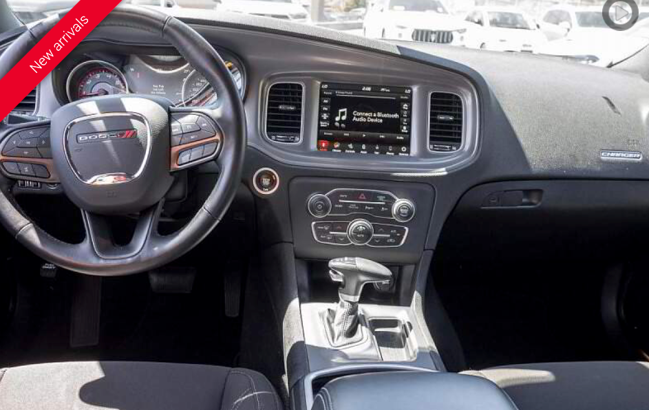 Black car interior with steering wheel, dashboard, and center console.