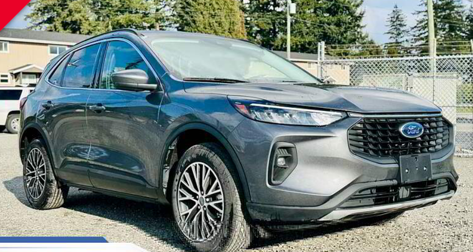 Gray Ford Escape SUV parked outdoors in front of a building and fence.