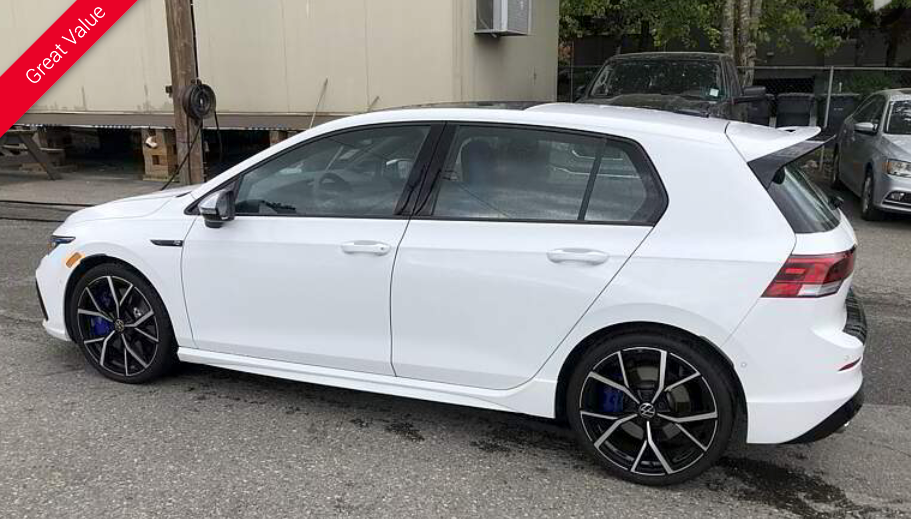 White hatchback car with black wheels parked outside, 
