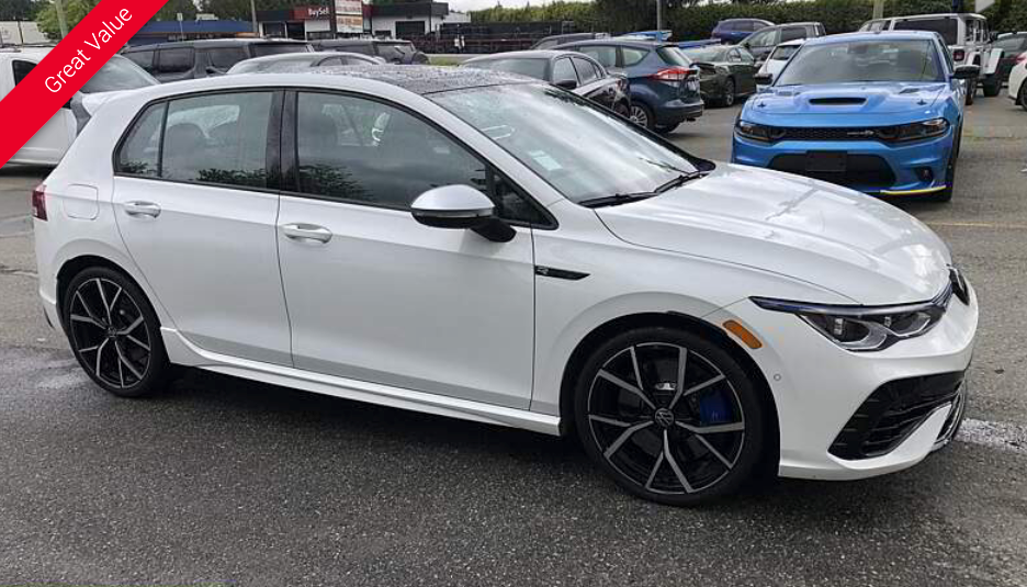 White Volkswagen Golf R parked on a lot. Black wheels, blue accents, red 