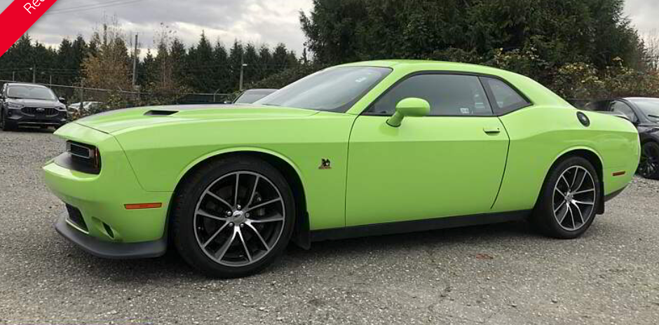 Green Dodge Challenger car parked outside.