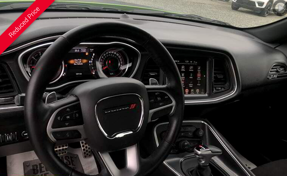 Interior of a Dodge Challenger, showing the dashboard, steering wheel, and infotainment screen.