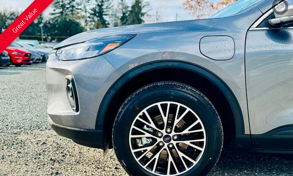 Close-up of a gray Ford Escape SUV with a charging port, parked outdoors.