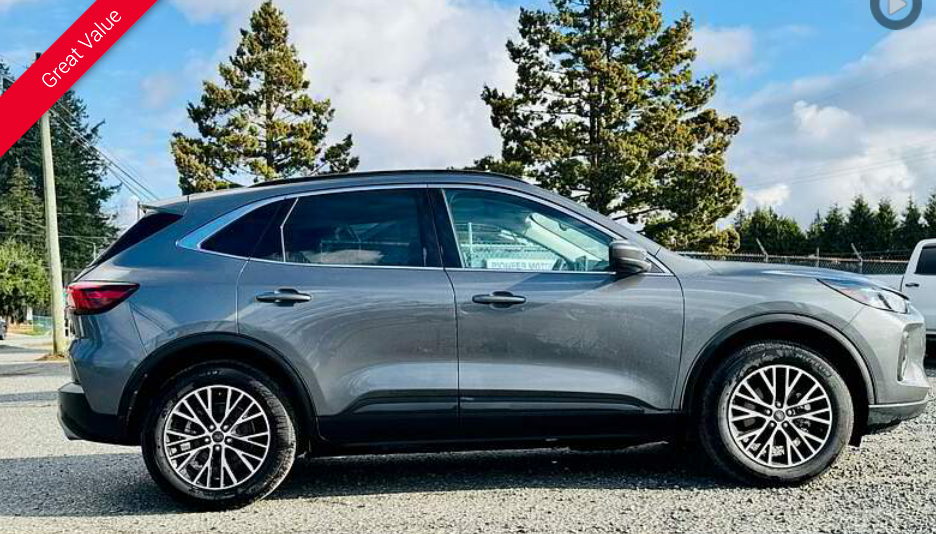 Gray SUV parked outdoors with black and silver wheels, under a bright sky.