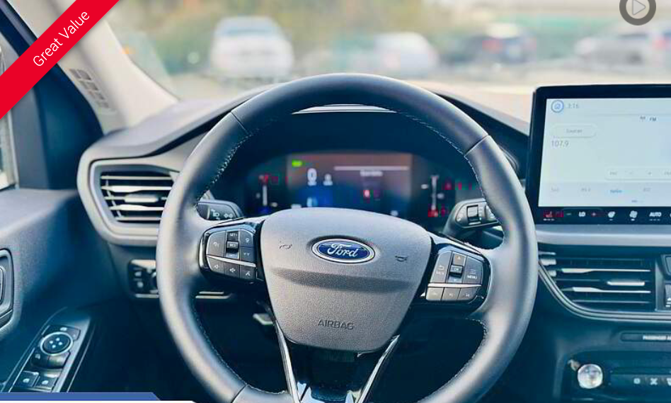 Interior view of a Ford car dashboard with steering wheel, digital displays, and controls.