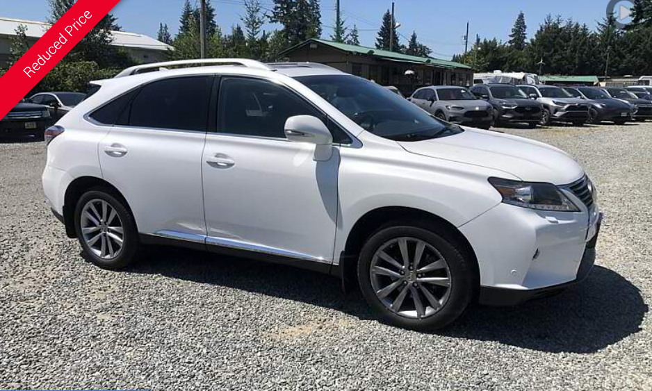White Lexus RX SUV parked on gravel lot.  