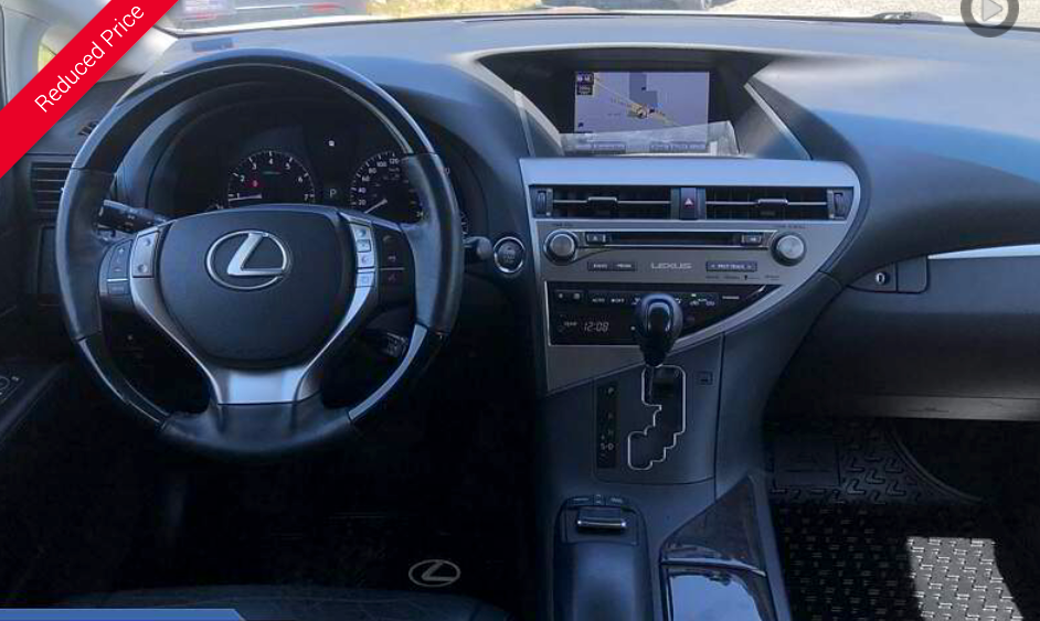 Interior of a Lexus car: dashboard, steering wheel, navigation screen, and center console.
