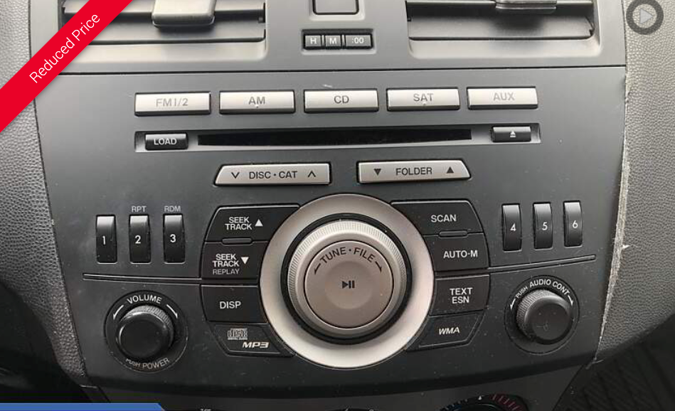 Car radio control panel with buttons, knobs, and a central dial.