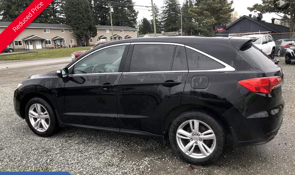 Black Acura RDX SUV parked on gravel, with red 