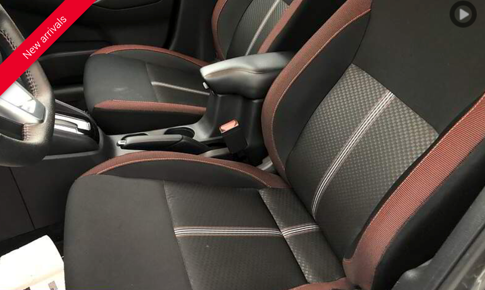 Black and brown car seats with an armrest inside a vehicle.
