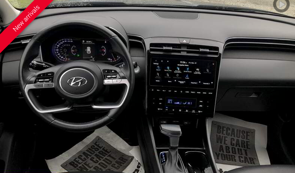 Hyundai Tucson dashboard with steering wheel, digital displays, and gear shift.