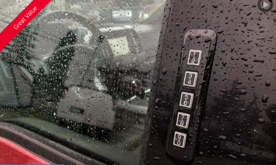 Exterior door keypad on a black vehicle in the rain.