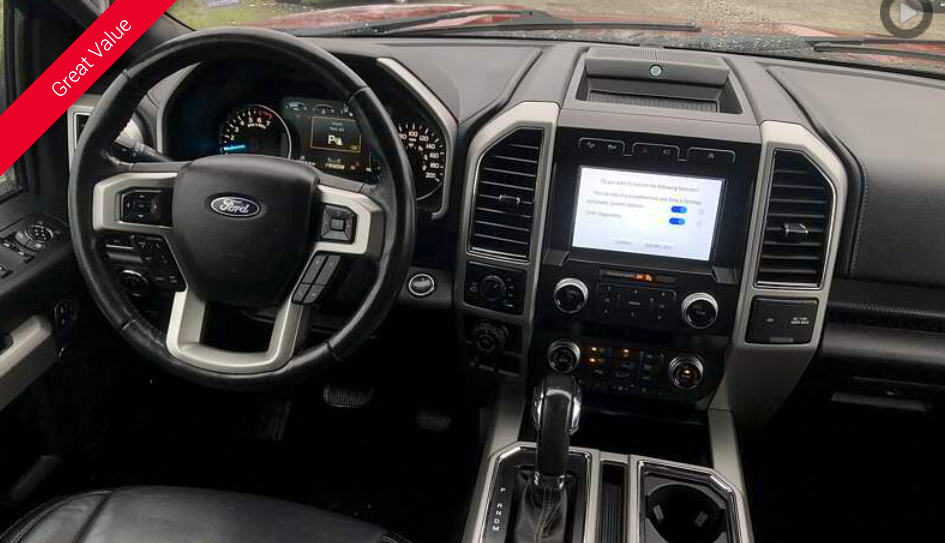 Ford F-150 truck interior. Dashboard with a steering wheel, central display screen, and gear shift.