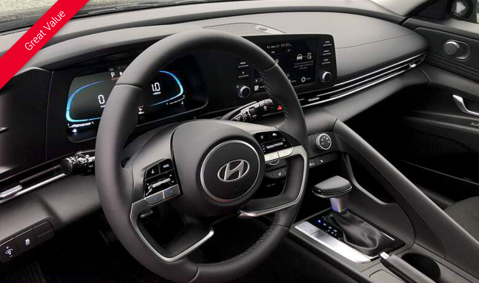 Black car interior with a steering wheel, dashboard, and digital displays.