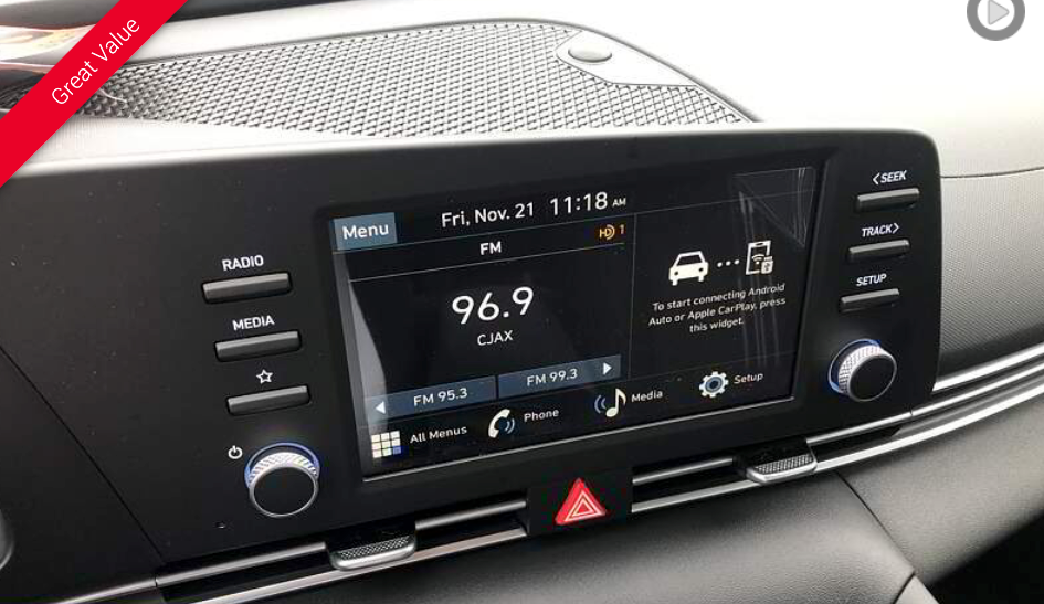 Dashboard infotainment screen in a car, displaying radio information and other vehicle features.