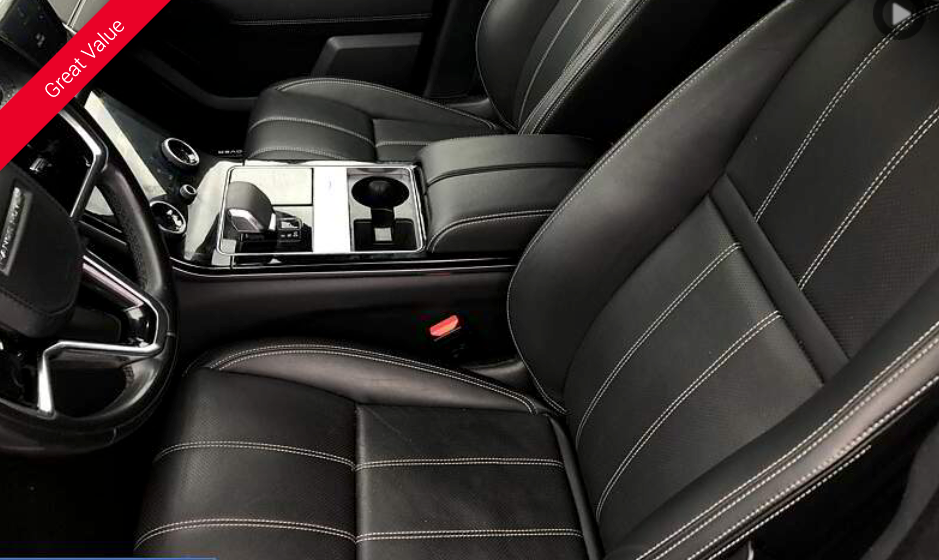 Black leather car seats with white stitching, center console, and steering wheel.