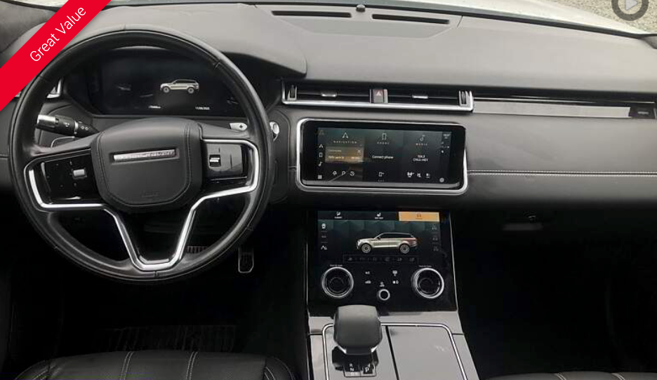 Interior of a Range Rover, black dashboard, infotainment screens, steering wheel.