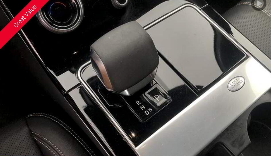 Black car's center console with gear selector and drive mode buttons. Glossy black and silver surfaces.