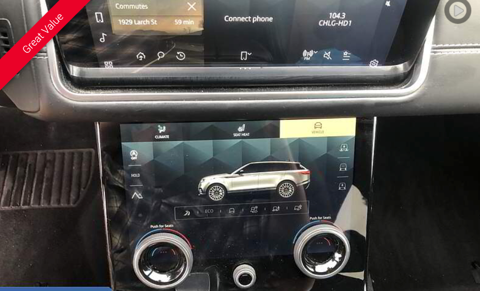 Car's dashboard with two touchscreens displaying navigation and vehicle settings; rotary dials below.