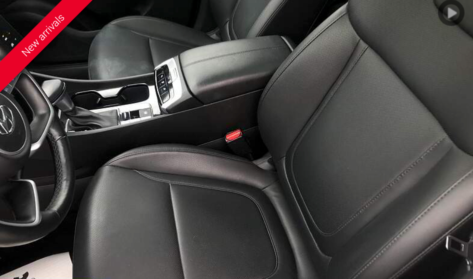 Black leather car interior with center console, cup holders, and front seats.