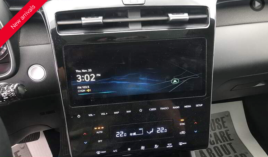 Car dashboard with large touchscreen displaying time, temperature, and navigation, with climate controls.