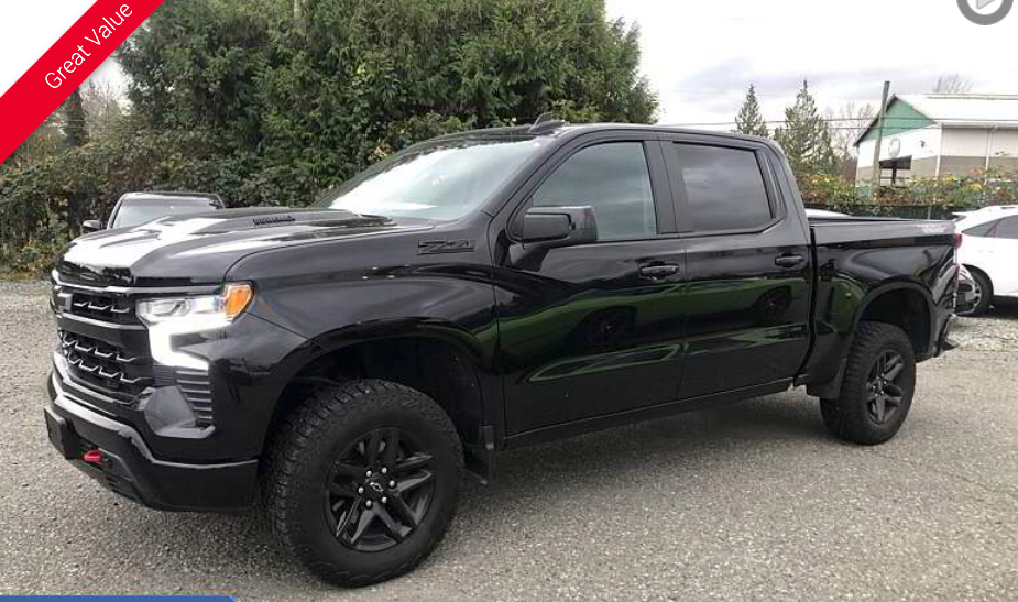 Black Chevrolet Silverado pickup truck with black wheels parked outside.