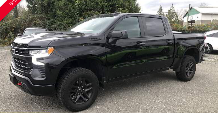 Black Chevrolet Silverado truck, parked outdoors. Black wheels, tinted windows.