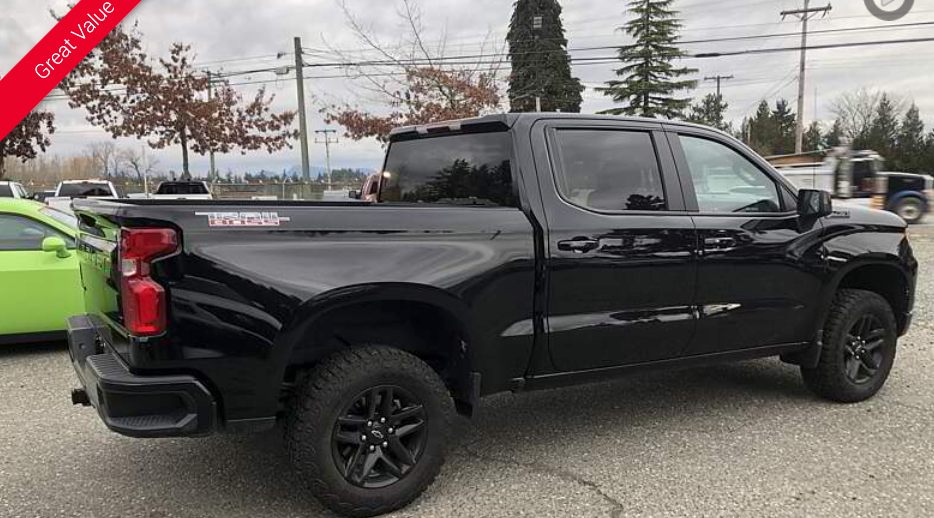 Black Chevrolet truck with black wheels parked outdoors.