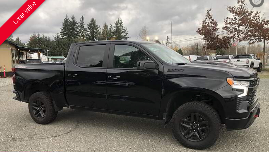 Black Chevrolet pickup truck parked outside on a cloudy day.