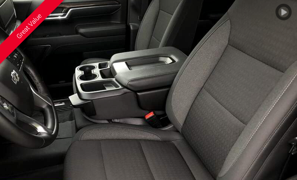 Interior view of a black truck with a center console, cup holders, and a black and gray seat.