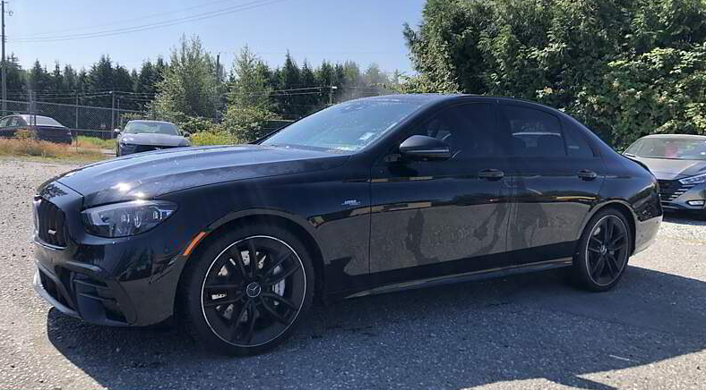 Black sedan parked outdoors on a sunny day.