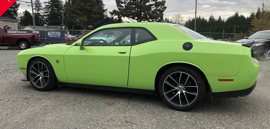 Green Dodge Challenger parked outside.