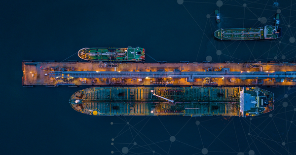 Container ship on water, loaded with colorful shipping containers.