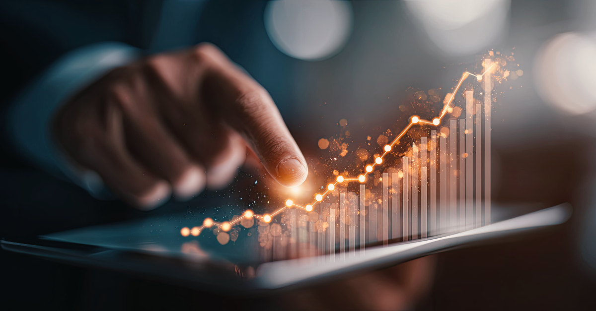 A hand touching a tablet displays a glowing, upward-trending graph.